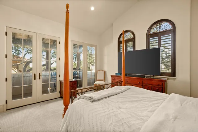 a bedroom with a bed and a flat tv screen on the dresser