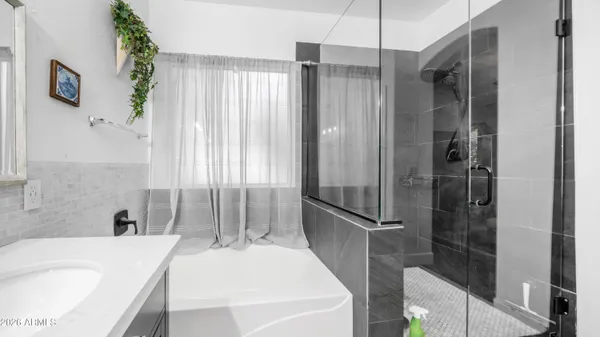 a bathroom with a tub sink and shower