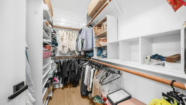 a view of walk in closet with clothes and shoes