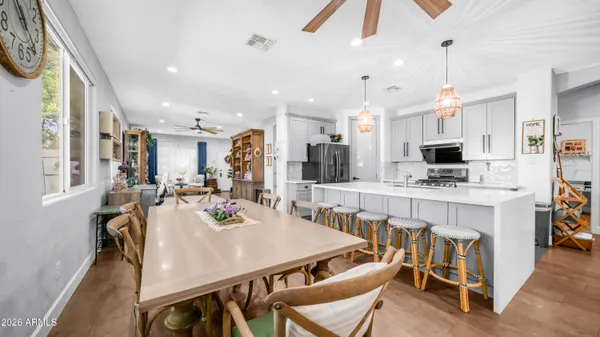 a view of kitchen with kitchen island stainless steel appliances refrigerator stove dining table and chairs