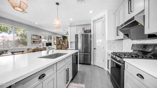 a kitchen with a sink stainless steel appliances a counter top space cabinets and a window