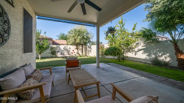 a view of a patio with table and chairs potted plants and a palm tree