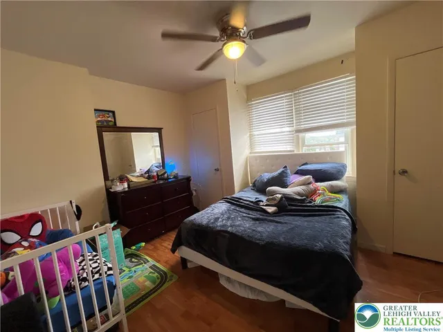 a bedroom with a bed a window and dresser