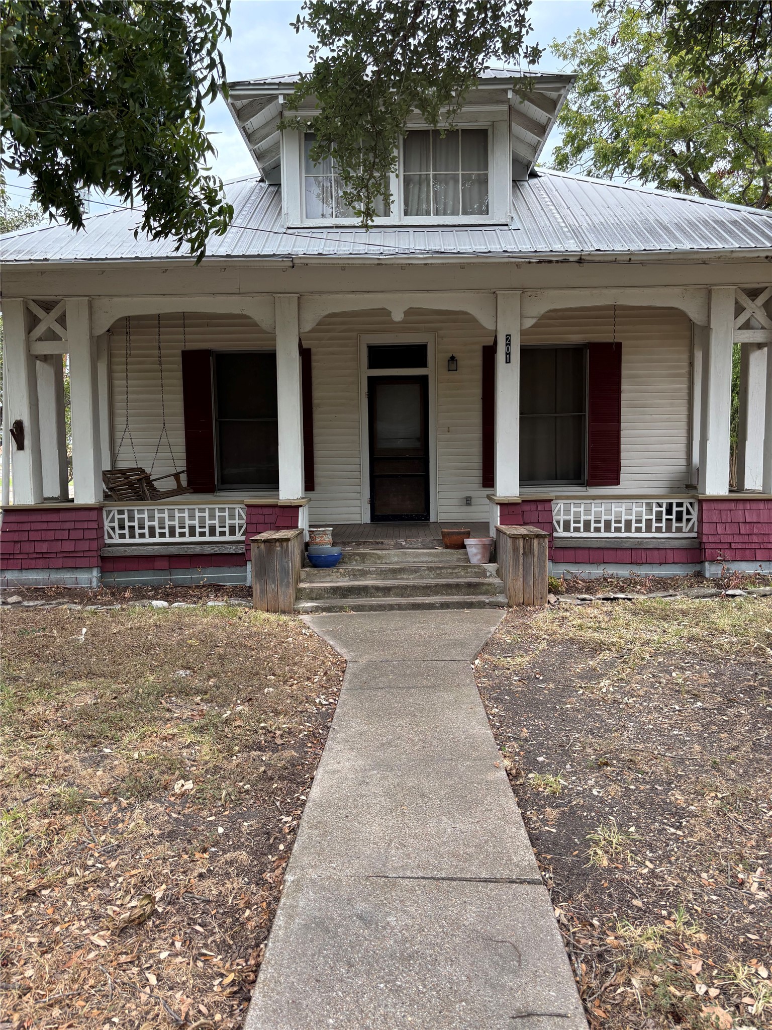 201 South Rio Grande Street Granger, TX 76530 - Photo 2 of 12 A welcoming front porch with classic columns and a metal roof defines this historic elevation.
