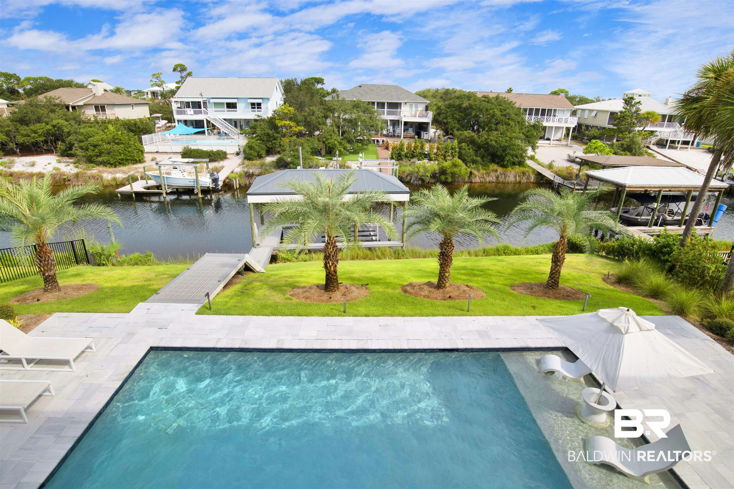 30239 Canal Court Orange Beach, AL 36561 - Photo 30 of 70 Swimming pool featuring a water view, a lawn, and a residential view