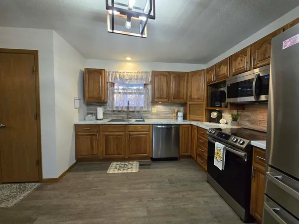 a kitchen with stainless steel appliances granite countertop a stove refrigerator sink and microwave