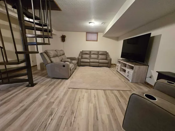 a living room with furniture wooden floor and a flat screen tv