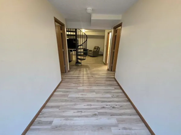 a room with a mirror on dresser and a wooden floor