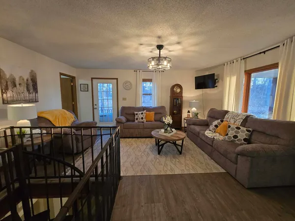 a living room with furniture a dining table and a chandelier