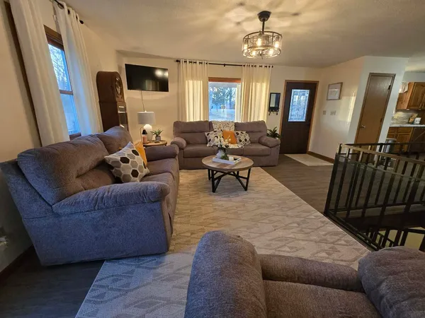 a living room with furniture wooden floor and a flat screen tv