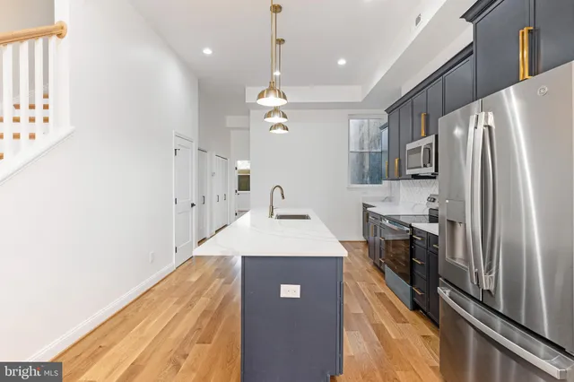 a kitchen with stainless steel appliances granite countertop a refrigerator a sink dishwasher a stove and a refrigerator