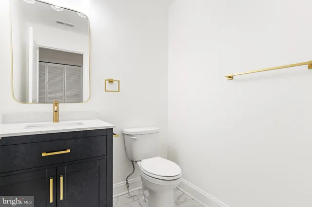 a bathroom with a toilet a sink and mirror