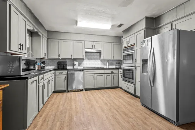 a kitchen with stainless steel appliances a refrigerator sink and cabinets