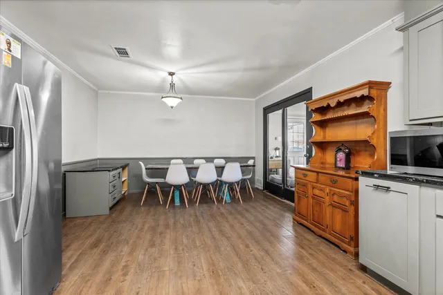 a kitchen with a table chairs refrigerator and microwave