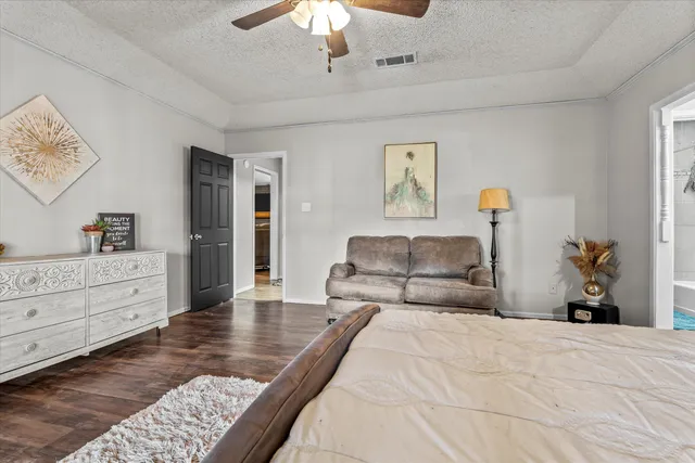 a bedroom with a large bed and a chandelier