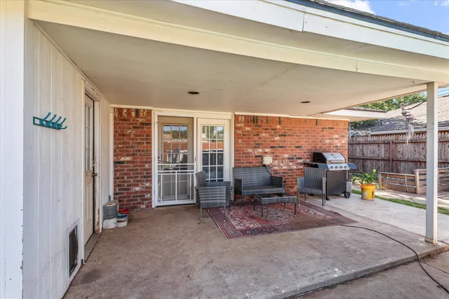 a white house with a large outdoor space and seating area