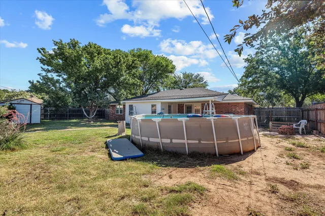 a view of a house with backyard and a tree