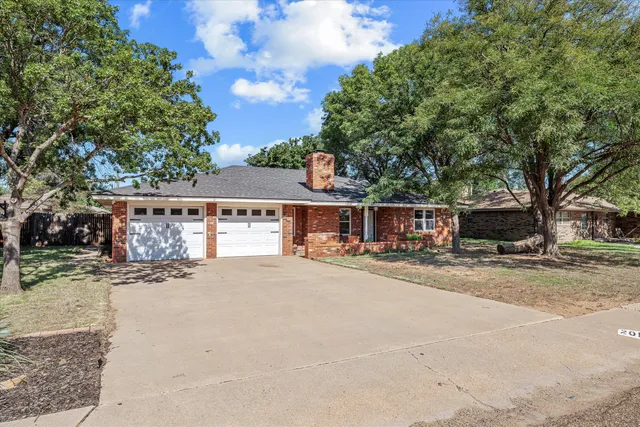 a view of a house with a yard and garage