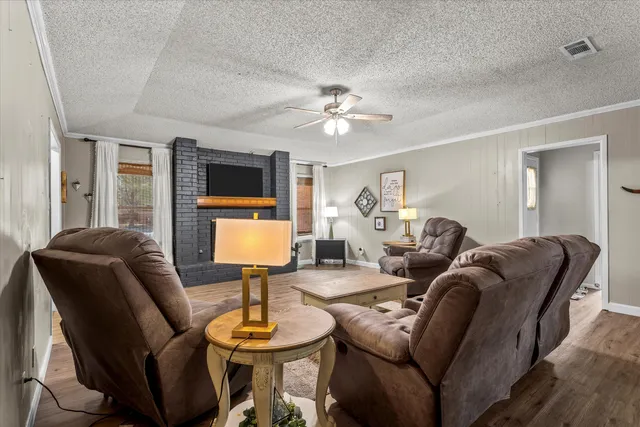 a living room with furniture a flat screen tv and a window