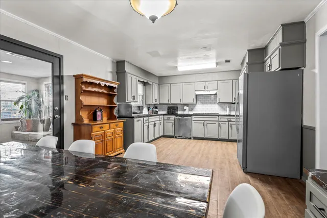 a kitchen with stainless steel appliances kitchen island granite countertop a refrigerator and a sink