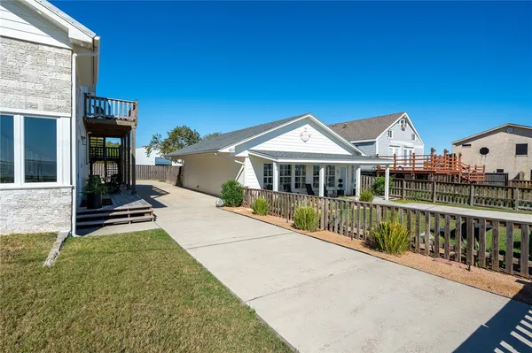 a view of house with a yard and potted plants