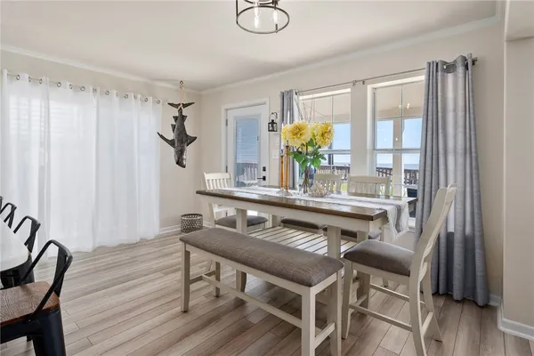 a kitchen with stainless steel appliances a dining table chairs in it and wooden floors