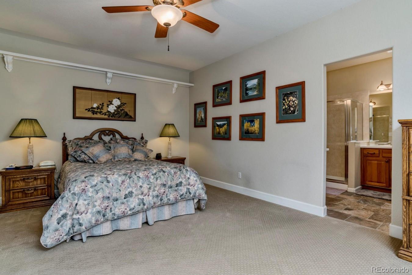 8974 Old Tom Morris Circle Highlands Ranch, CO 80129 - Photo 14 of 28 a bedroom with bed and a chandelier