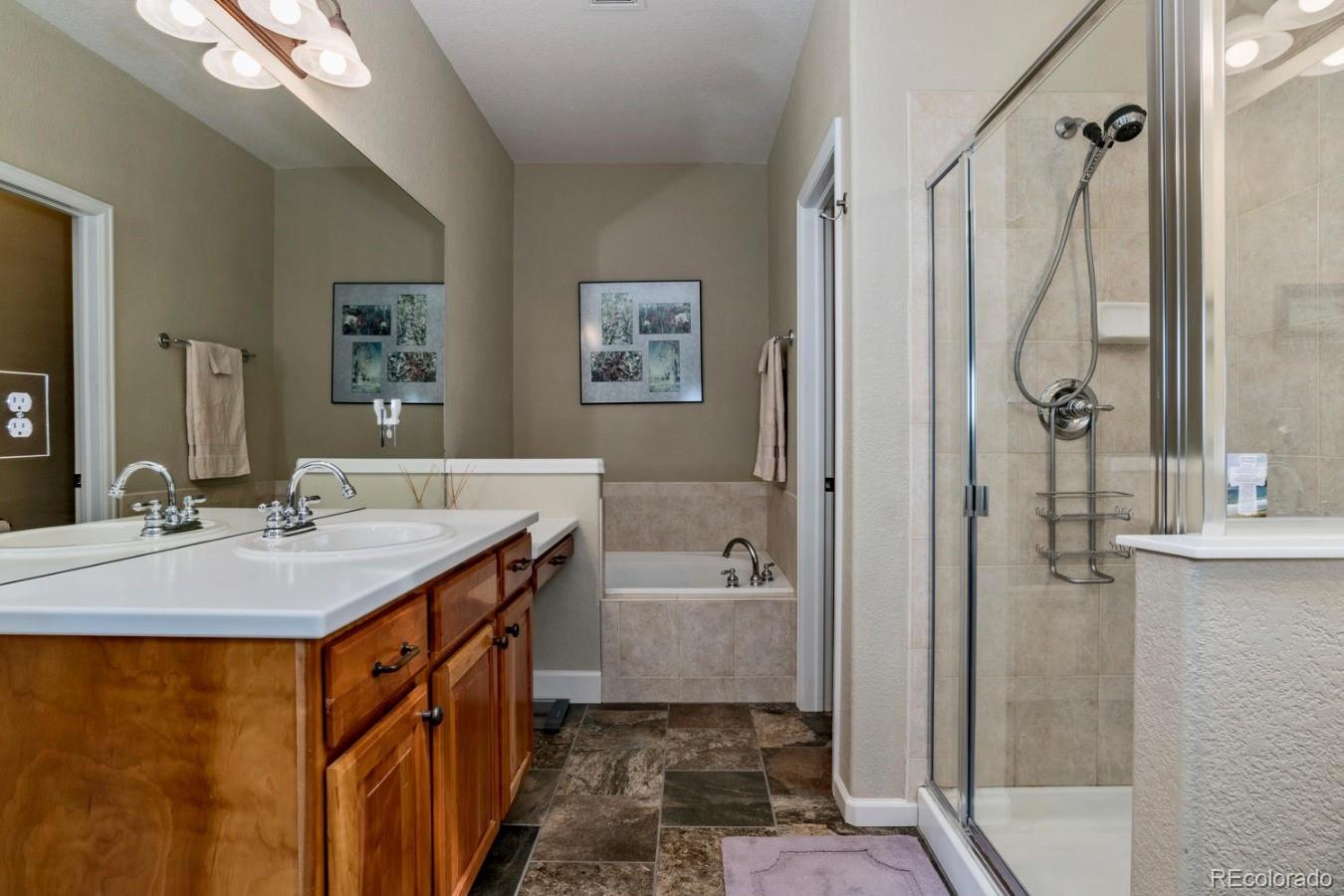 8974 Old Tom Morris Circle Highlands Ranch, CO 80129 - Photo 16 of 28 a bathroom with a granite countertop sink a mirror a vanity and a shower