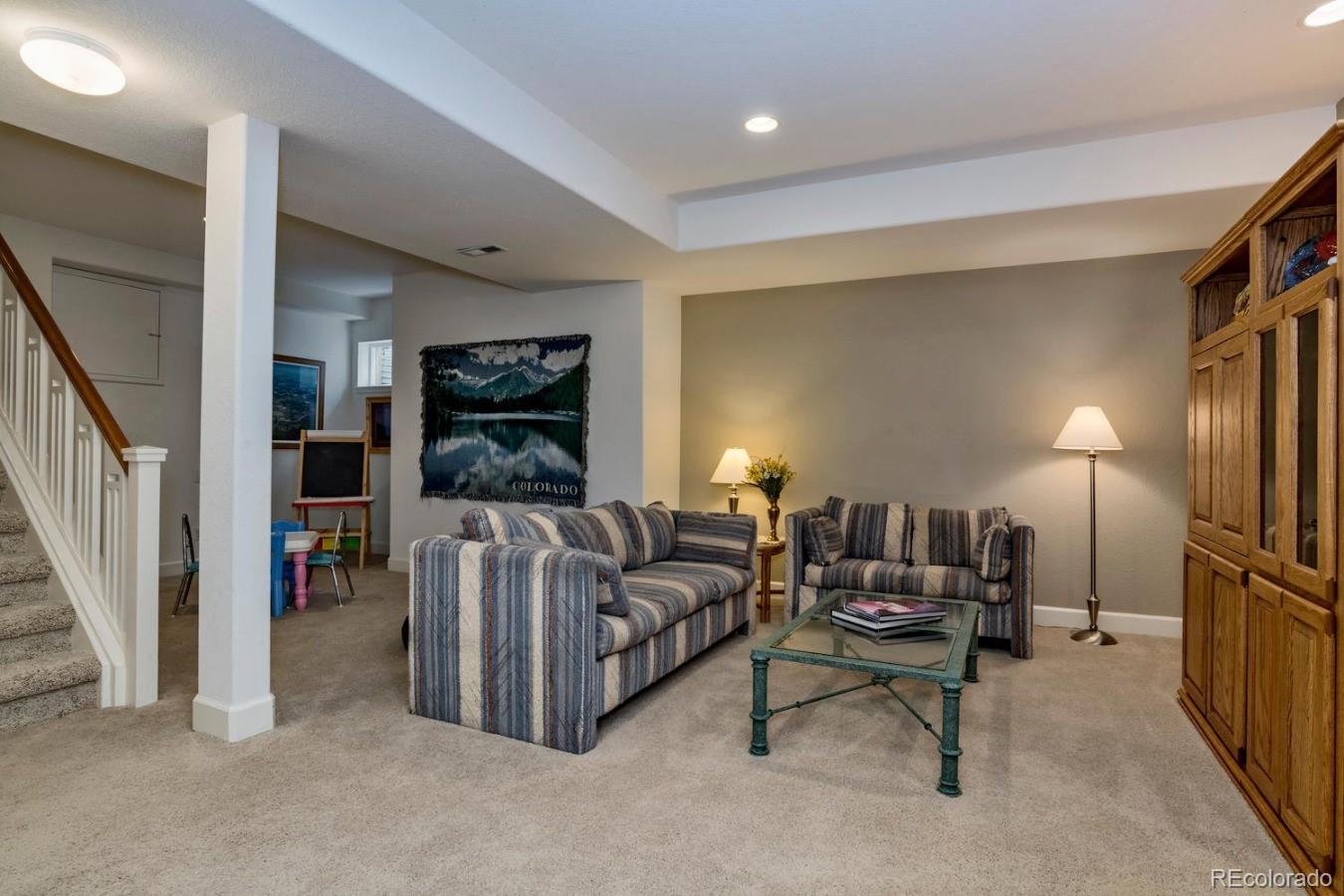 8974 Old Tom Morris Circle Highlands Ranch, CO 80129 - Photo 23 of 28 a living room with furniture and a flat screen tv