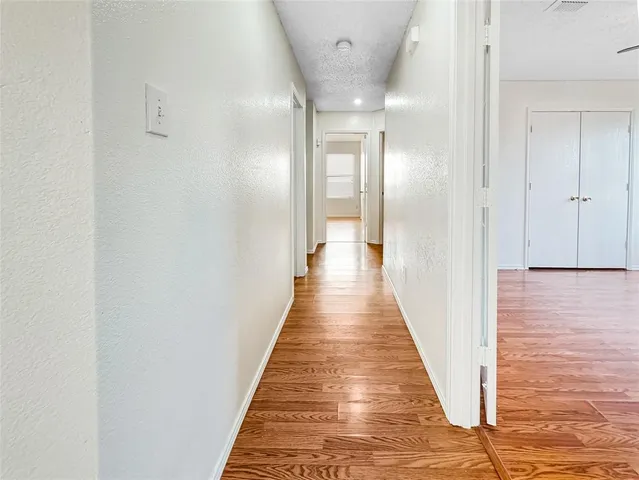 a view of a hallway with wooden floor