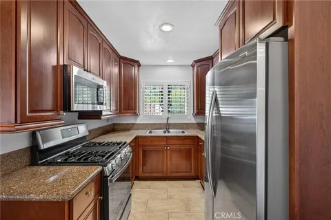 a kitchen with stainless steel appliances granite countertop a stove a refrigerator and a sink