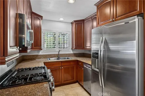 a kitchen with stainless steel appliances granite countertop a stove a sink and a refrigerator