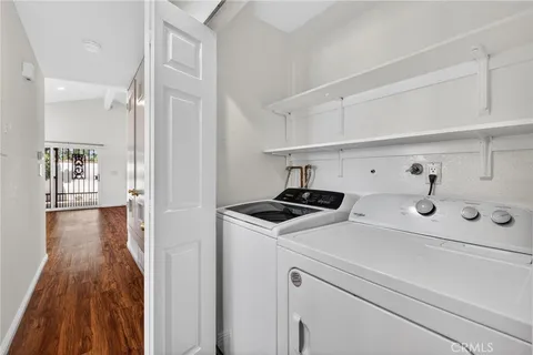 a view of washer and dryer with kitchen in the background