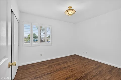 an empty room with a window and wooden floor