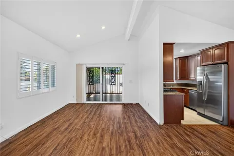 a view of a kitchen with wooden floor a ceiling fan and windows
