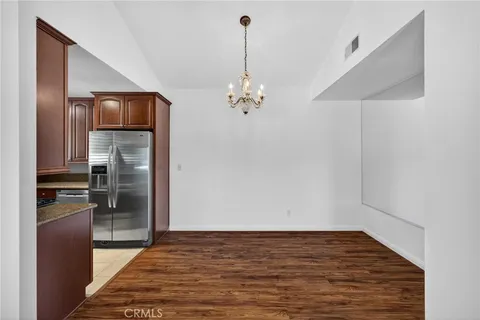 a view of a kitchen with a refrigerator and a stove top oven