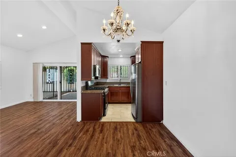 a view of a kitchen with kitchen island wooden floor center island and stainless steel appliances