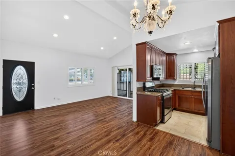 a large kitchen with stainless steel appliances granite countertop a stove and a wooden floors