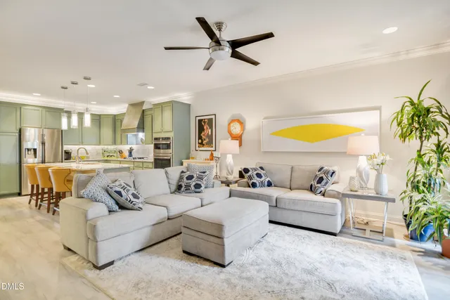a living room with furniture kitchen view and a large window