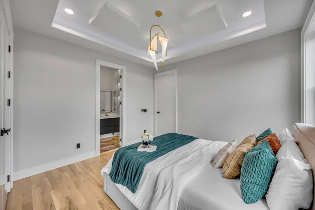 a bedroom with a bed and a chandelier