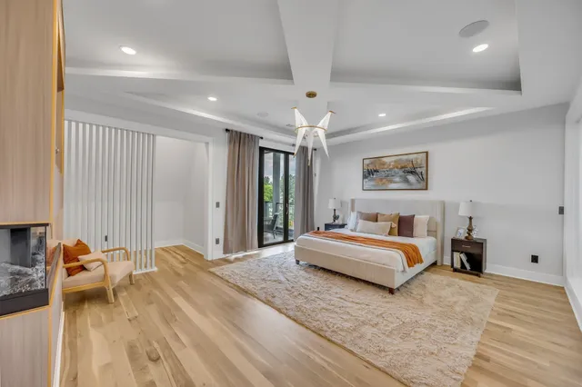 a spacious bedroom with a bed a table and a large mirror