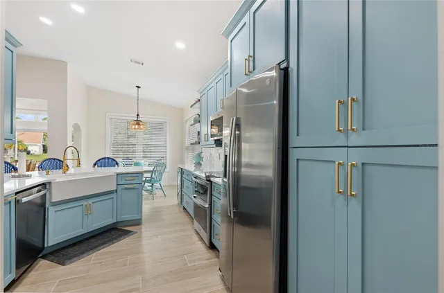 a kitchen with stainless steel appliances a refrigerator sink and stove