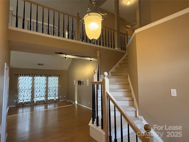 a view of a livingroom with wooden floor and a staircase