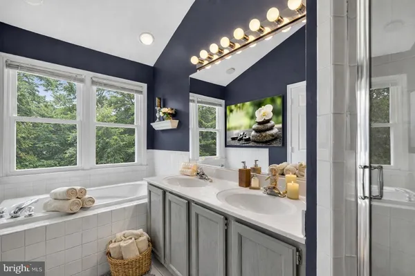 a bathroom with a tub sink and large window