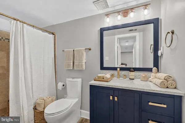 a bathroom with a granite countertop sink toilet a mirror and shower