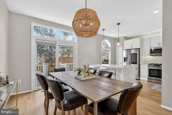 a dining room with furniture a chandelier and wooden floor