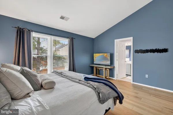 a bedroom with a bed and a flat tv screen on dresser