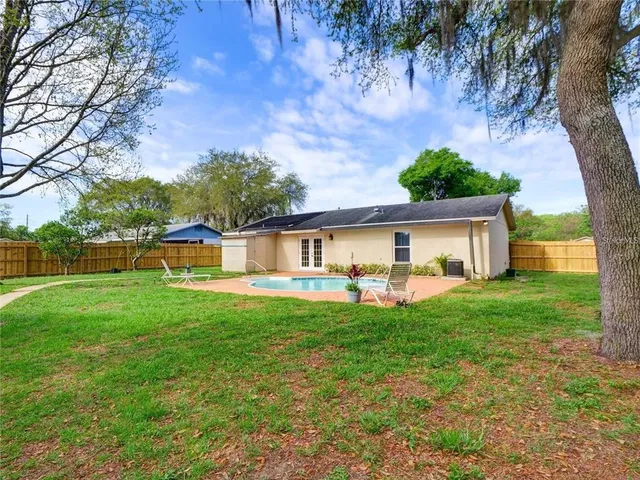 a view of a house with a yard and sitting area