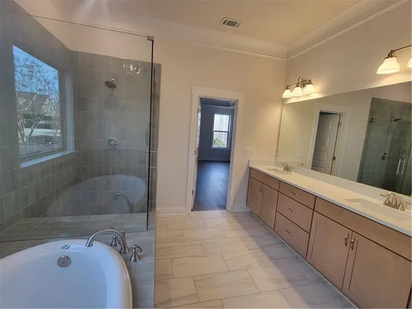 a bathroom with a bathtub shower sink and mirror