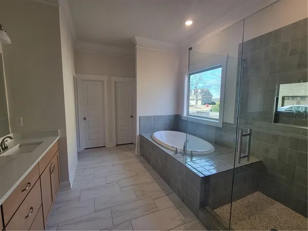 a spacious bathroom with a granite countertop sink mirror and bathtub